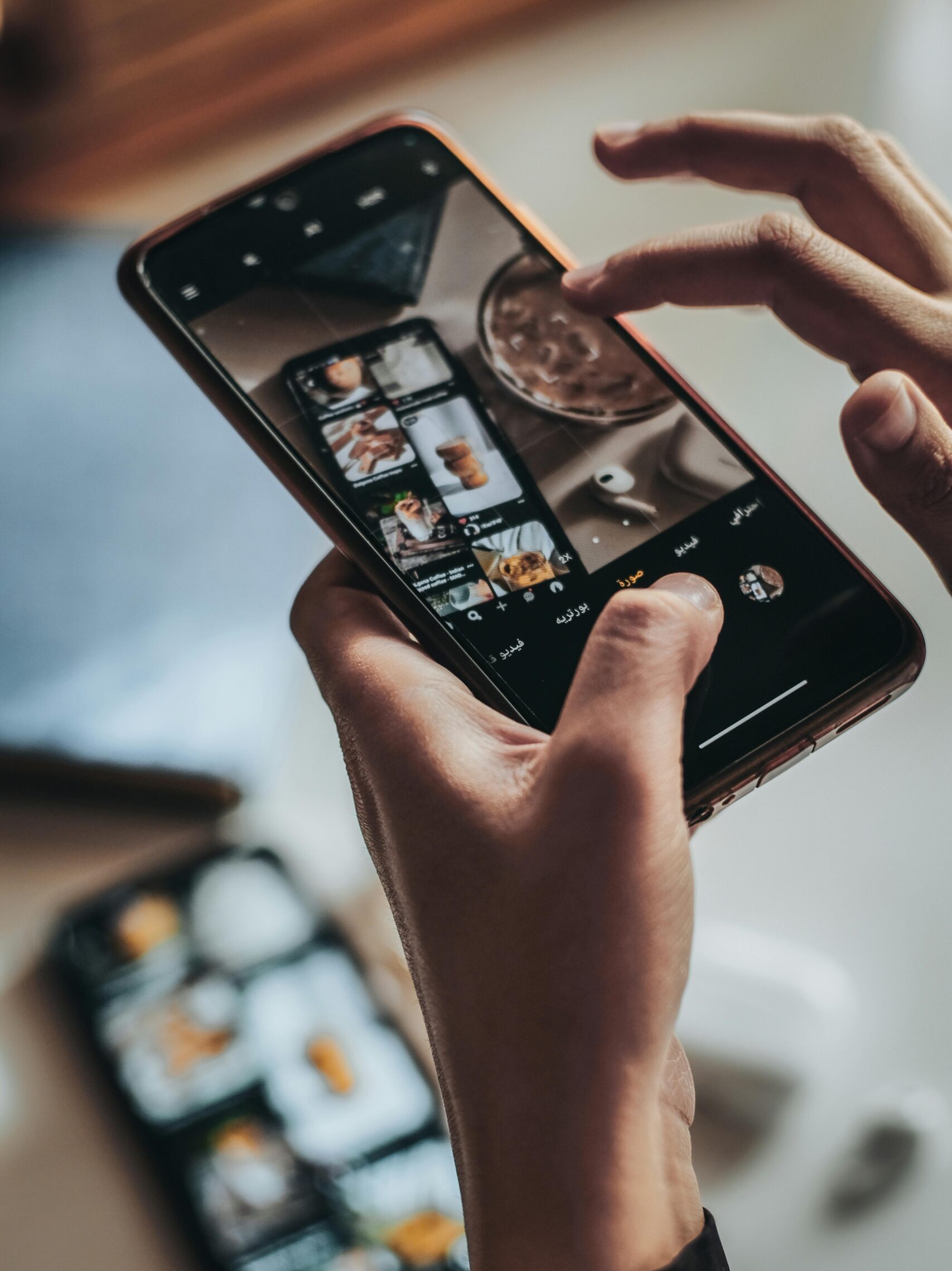Hands using a smartphone to take pictures, showcasing technology in Tadjenanet, Algiers.